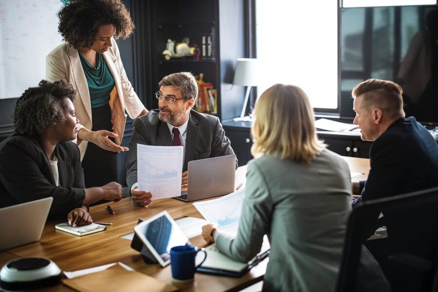Reunião de equipe em volta de uma mesa de escritório corporativo
