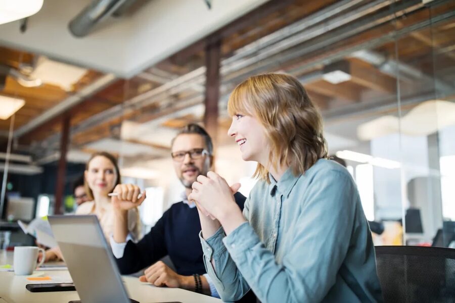 Equipe reunida à mesa de trabalho num escritório, analisando um projeto